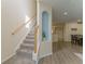 Bright hallway featuring a carpeted staircase, alcove with decor, and open doorway at 11277 Osage Cir # E, Westminster, CO 80234