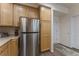 Kitchen features stainless steel refrigerator and wooden cabinets at 11277 Osage Cir # E, Westminster, CO 80234