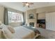 Comfortable main bedroom with a fireplace, ceiling fan, and bright sunny windows at 11277 Osage Cir # E, Westminster, CO 80234