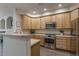 Modern kitchen features stainless steel appliances, ample wood cabinets, and a breakfast bar at 11277 Osage Cir # E, Westminster, CO 80234