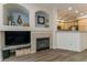 Inviting living room with a fireplace, custom built-ins, and views into the adjacent kitchen area at 11277 Osage Cir # E, Westminster, CO 80234
