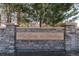 Stone monument sign reading 'Highlands at Westbury' surrounded by mature trees and manicured landscape at 11277 Osage Cir # E, Westminster, CO 80234