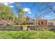 Spacious backyard with mature trees and a low brick wall surrounding the property at 6285 W 35Th Ave, Wheat Ridge, CO 80033