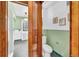 View into bathroom with a toilet and green and white tiled walls at 6285 W 35Th Ave, Wheat Ridge, CO 80033