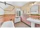 Vintage bathroom featuring original tile, a pedestal sink, and a soaking tub at 6285 W 35Th Ave, Wheat Ridge, CO 80033