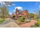 Brick home with driveway leading to detached garage, complemented by mature landscaping and a red brick walkway at 6285 W 35Th Ave, Wheat Ridge, CO 80033