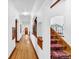 Bright hallway featuring hardwood flooring, arched doorways, and decorative iron staircase at 6285 W 35Th Ave, Wheat Ridge, CO 80033