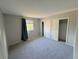 Empty bedroom with neutral carpet, natural light, and a large closet with sliding doors at 9852 W 76Th Ave, Arvada, CO 80005