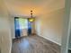 Dining room featuring modern flooring, a chandelier, and blue curtains at 9852 W 76Th Ave, Arvada, CO 80005