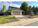 Two-story home with green siding, brick accents, and a well-manicured lawn at 9852 W 76Th Ave, Arvada, CO 80005