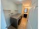 Convenient laundry area including shelving and a full-sized washer and dryer set, located near a half bathroom at 9852 W 76Th Ave, Arvada, CO 80005