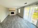 Spacious living room featuring gray flooring, a fireplace, and natural light from the sliding glass door to the backyard at 9852 W 76Th Ave, Arvada, CO 80005