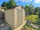 Exterior view of a shed with an access door, adjacent to a wooden fence and scattered vegetation at 9852 W 76Th Ave, Arvada, CO 80005