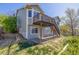 Exterior view of a home with a wooden deck and a spacious backyard on a sunny day at 5335 S Lisbon Way, Centennial, CO 80015