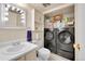 Bathroom featuring a modern vanity, toilet, and convenient in-unit washer and dryer at 6650 E Arizona Ave # 163, Denver, CO 80224