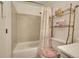 Bathtub and shower combination with a decorative shower curtain and a shelving unit with plush towels at 6650 E Arizona Ave # 163, Denver, CO 80224