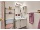 Bathroom with a white vanity, a mirror with vanity lights, and a toilet next to a shelving unit at 6650 E Arizona Ave # 163, Denver, CO 80224