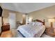 Cozy bedroom featuring a plush queen-sized bed with a floral comforter and matching pillows, with a wooden nightstand and lamp at 6650 E Arizona Ave # 163, Denver, CO 80224