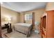 Bedroom with a queen bed, a desk with a lamp, a window with curtains, and a wooden bookcase at 6650 E Arizona Ave # 163, Denver, CO 80224