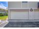 Attached garages with a driveway and front lawn. Condo unit numbers on the building at 6650 E Arizona Ave # 163, Denver, CO 80224