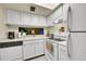 Well-lit kitchen with white cabinets and appliances, offering a clean and functional space for cooking at 6650 E Arizona Ave # 163, Denver, CO 80224