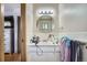 A bright bathroom featuring a white vanity and a round mirror above the sink at 4465 Cody St, Wheat Ridge, CO 80033