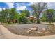 View of a home with a xeriscaped front yard featuring rocks and mature trees at 4465 Cody St, Wheat Ridge, CO 80033