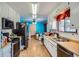 Bright kitchen with white cabinets, black appliances, light wood floors, and a pop of blue on the walls at 4465 Cody St, Wheat Ridge, CO 80033
