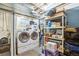 This laundry room features a washer, dryer and shelving units at 11228 W 18Th Ave, Lakewood, CO 80215