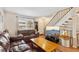 Inviting living room featuring a comfortable leather sofa, a bright window and staircase with natural light at 11228 W 18Th Ave, Lakewood, CO 80215