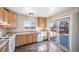 Sunlit kitchen features light wood cabinets, stainless steel sink, white appliances, and backyard access at 20615 E Coolidge Pl, Aurora, CO 80011