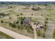 Aerial view of a home with deck, driveway, outbuildings, and surrounded by trees at 1559 Lisbon Dr, Parker, CO 80138
