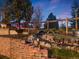 Scenic backyard featuring a rock-lined stream, lush foliage, and a charming wooden fence at 1559 Lisbon Dr, Parker, CO 80138