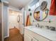 Bathroom features a modern sink, decorative mirror and adjacent door with towel rack at 1559 Lisbon Dr, Parker, CO 80138