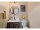 Nicely decorated half bathroom with a round mirror, dark cabinets, and modern fixtures at 8015 Lt William Clark Rd, Parker, CO 80134