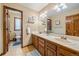 Bright bathroom featuring dual sinks, wood cabinetry, and a separate toilet room for added privacy at 8015 Lt William Clark Rd, Parker, CO 80134