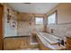 Bright bathroom with walk in shower, soaking tub, tiled walls and bronze fixtures at 8015 Lt William Clark Rd, Parker, CO 80134