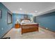 Cozy blue bedroom with a wooden bed frame, plush rug, and soft lighting for a relaxing atmosphere at 8015 Lt William Clark Rd, Parker, CO 80134