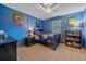 Bright bedroom with blue walls featuring a bed, a bookcase and sporty decor at 8015 Lt William Clark Rd, Parker, CO 80134