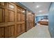Hallway with wood panel doors leading into a bedroom with a wooden bed frame and blue painted walls at 8015 Lt William Clark Rd, Parker, CO 80134
