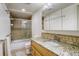 Bathroom with granite countertops, a shower and a mirrored cabinet at 709 S Depew St, Lakewood, CO 80226