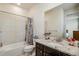 Bright bathroom featuring neutral tile flooring, bath tub, toilet, vanity with hard surface counters, faucet and a large mirror at 19471 W 59Th Ave, Golden, CO 80403