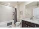 Bright bathroom with a shower-tub combination, tile flooring, dark vanity and a hard surface counter with faucet at 19471 W 59Th Ave, Golden, CO 80403