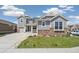 Beautiful two-story home with gray siding, stone accents, well-manicured lawn, and a two-car garage at 19471 W 59Th Ave, Golden, CO 80403