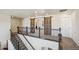 Second floor hallway with rod iron banister, carpeted floor and decorative barn doors at 19471 W 59Th Ave, Golden, CO 80403