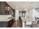 An open kitchen design with a huge island, dark cabinets, stainless appliances, and hardwood floors at 19471 W 59Th Ave, Golden, CO 80403