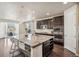 Modern kitchen featuring island with bar seating, dark cabinets, granite countertops, and stainless appliances at 19471 W 59Th Ave, Golden, CO 80403
