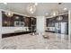 A large kitchen island is topped with granite and illuminated by pendant lights and stainless appliances at 19471 W 59Th Ave, Golden, CO 80403