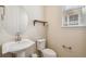 A simple powder room is designed with pedestal sink, round mirror, and floating shelf at 19471 W 59Th Ave, Golden, CO 80403