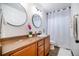 Bathroom featuring dual circular mirrors, and a shower with white curtain at 10669 Worchester Dr, Commerce City, CO 80022